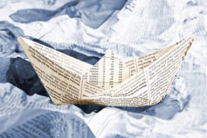 Newspaper boat over newspapers waves